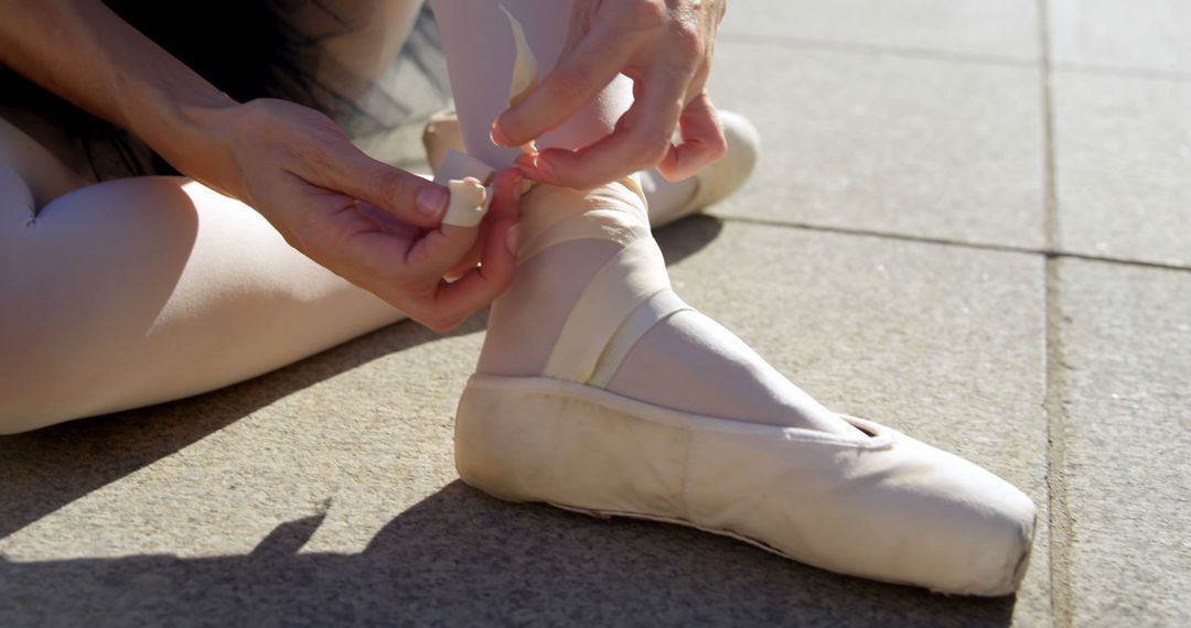Ballerina ties her pointe shoes outdoor, with copy space - Free Images, Stock Photos and Pictures on Pikwizard.com