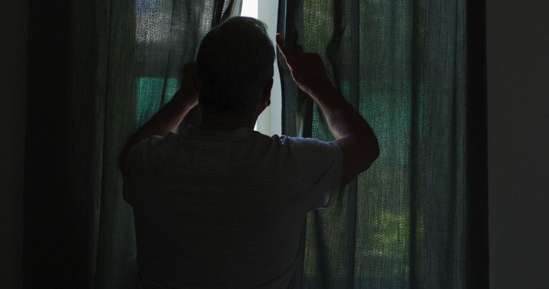 Silhouette of Man Pulling Dark Curtains Apart to Look Outside Window - Free Images, Stock Photos and Pictures on Pikwizard.com