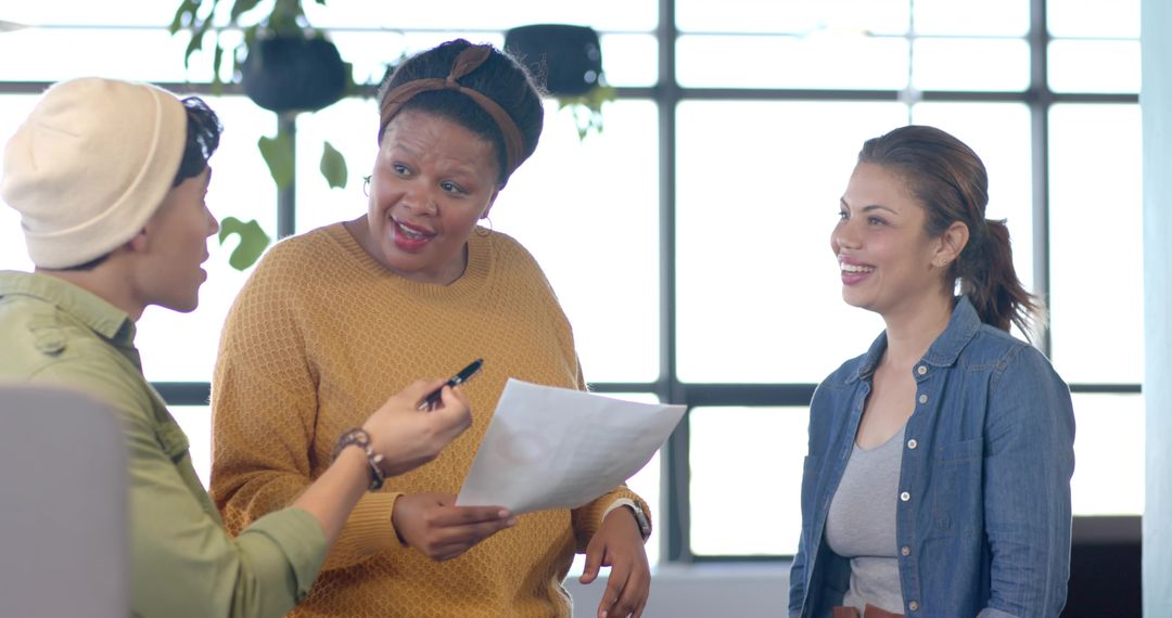 Diverse team brainstorming and sharing ideas in bright modern office lounge