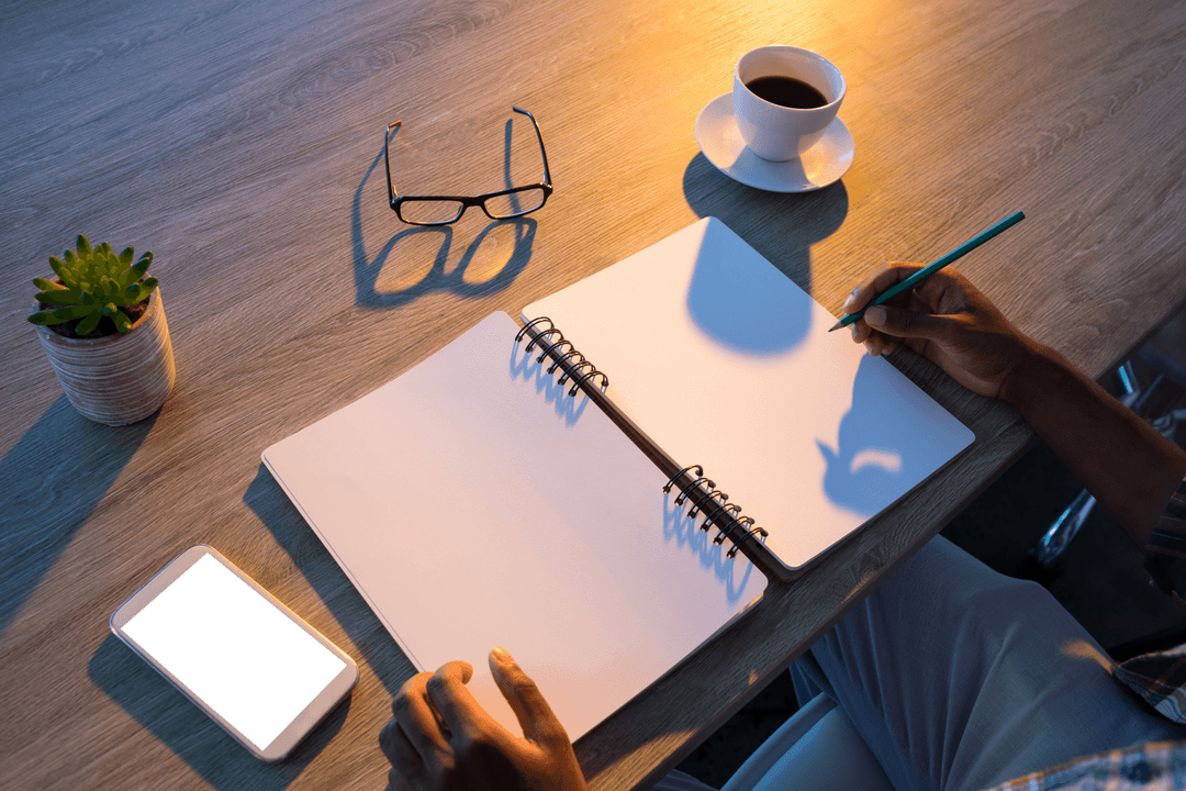 Transparent Desk Workspace with Hands Writing in Notepad