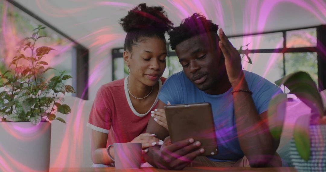 Couple Relaxing at Home viewing Tablet Surrounded by Nature’s Touch