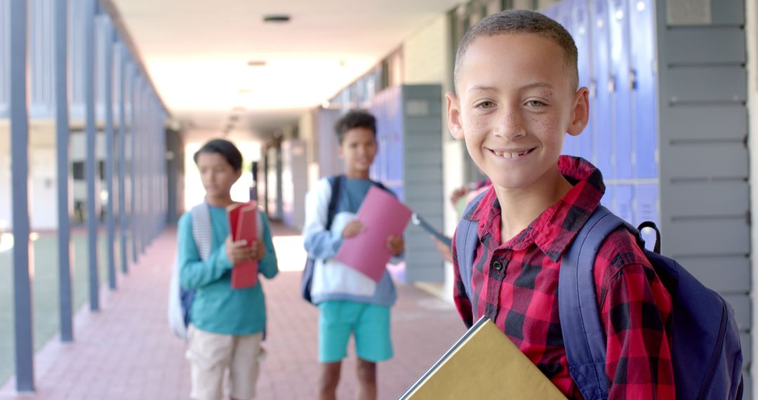 Boys Smiling in School Hallway with Backpacks and Notebooks