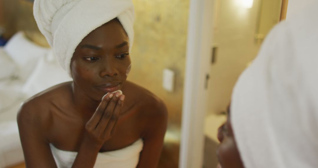 African American Woman Doing Skincare Routine With Towel On Her Hair - Free Images, Stock Photos and Pictures on Pikwizard.com