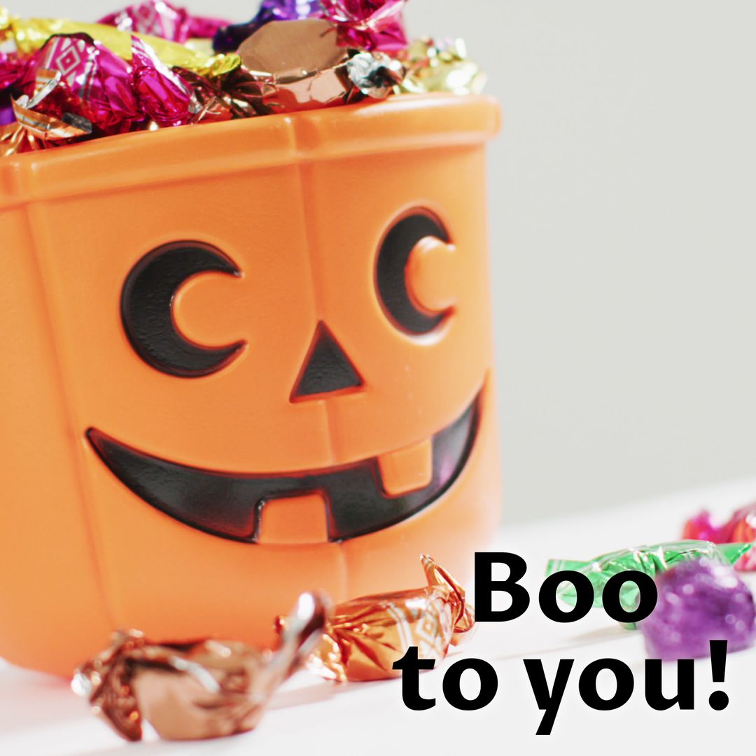 Halloween Pumpkin Basket Filled with Candy on White Background