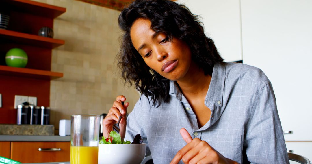 Young Woman Enjoys Fresh Salad in Modern Kitchen - Free Images, Stock Photos and Pictures on Pikwizard.com