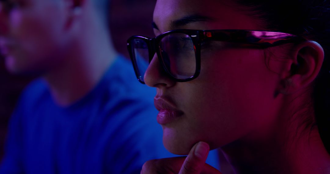 Young Woman with Glasses Focused on Computer Screen