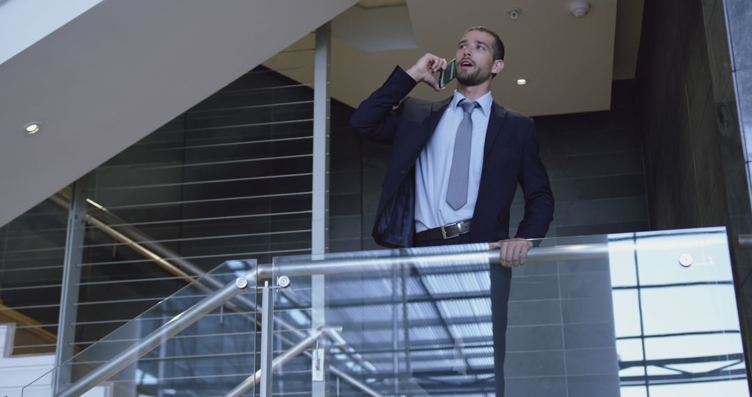 Businessman Talking on Phone in Modern Office Building - Free Images, Stock Photos and Pictures on Pikwizard.com