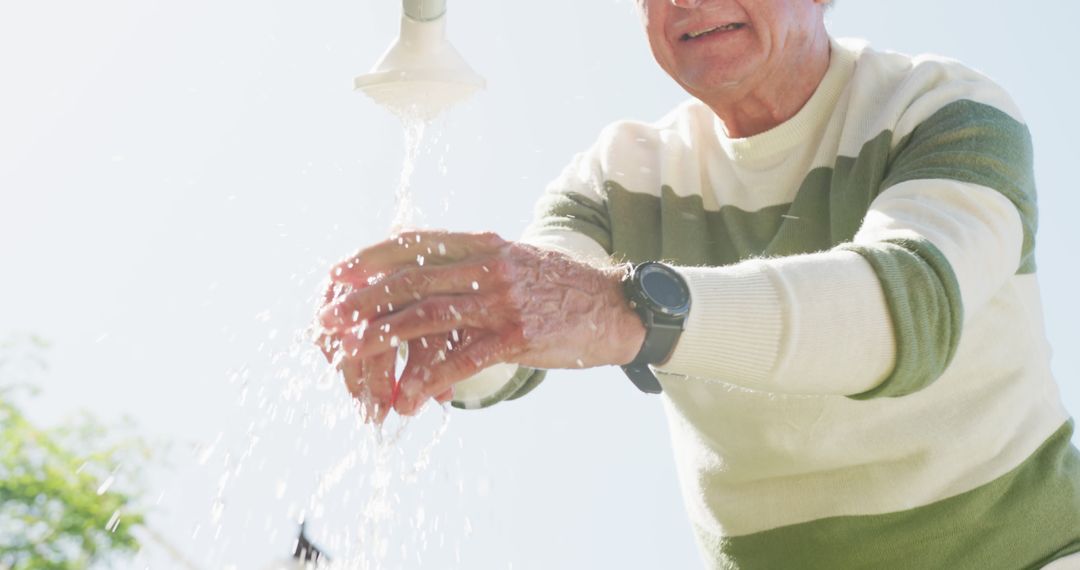 Senior Man Washing Hands Outdoors Under Running Faucet - Free Images, Stock Photos and Pictures on Pikwizard.com