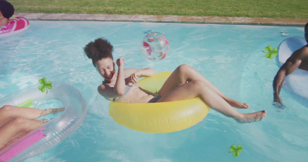 Laughing woman on yellow inflatable ring enjoying summer backyard pool party with friends