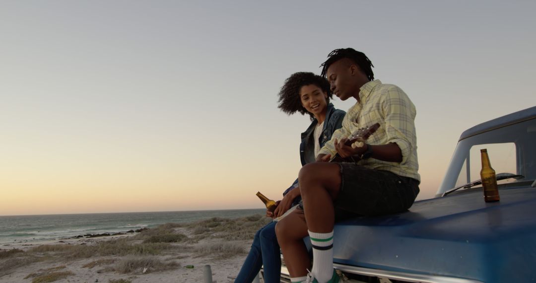 Young Couple Enjoying Beach Sunset with Guitar on Car can - Free Images, Stock Photos and Pictures on Pikwizard.com