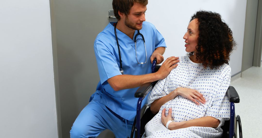 Caring nurse assisting pregnant woman in wheelchair at hospital - Free Images, Stock Photos and Pictures on Pikwizard.com