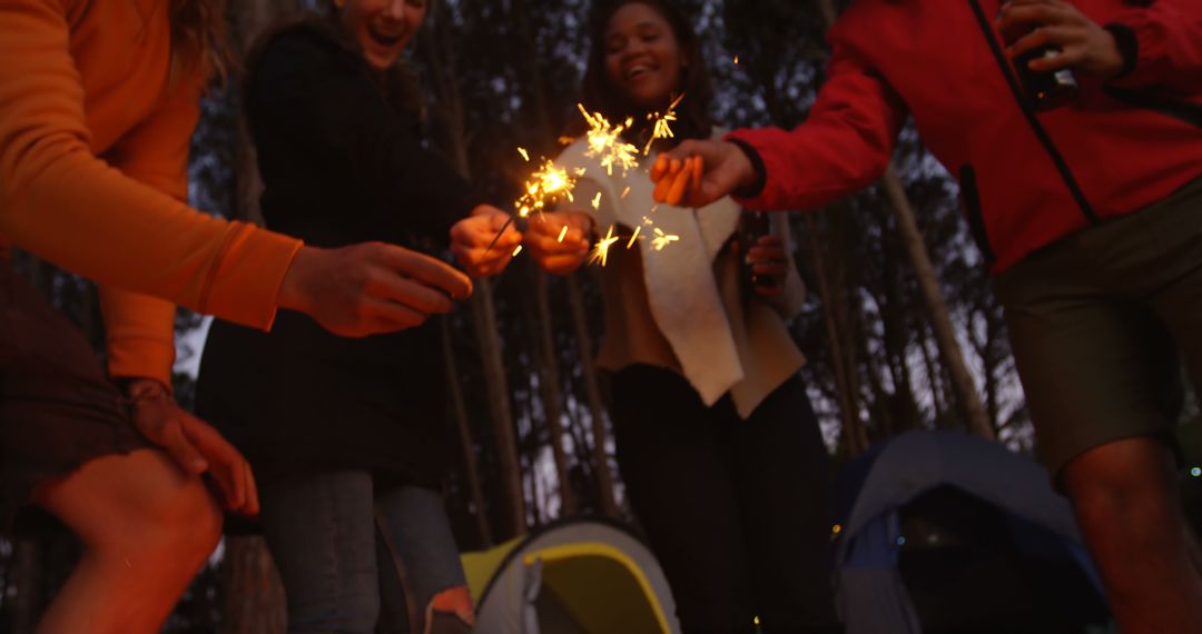 Friends Celebrating with Sparklers in Forest Campground - Free Images, Stock Photos and Pictures on Pikwizard.com