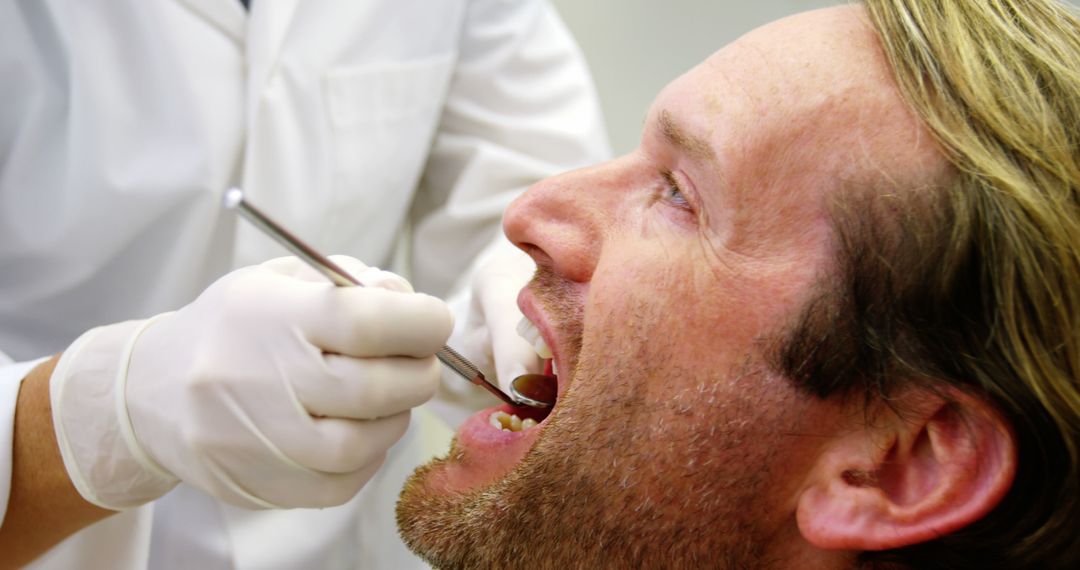 Dentist Examining Male Patient with Dental Tools - Free Images, Stock Photos and Pictures on Pikwizard.com