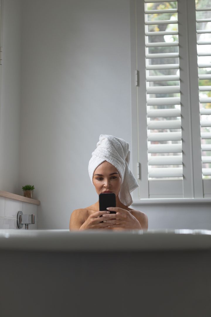 Woman Using Phone in Bathtub with Towel on Head - Free Images, Stock Photos and Pictures on Pikwizard.com