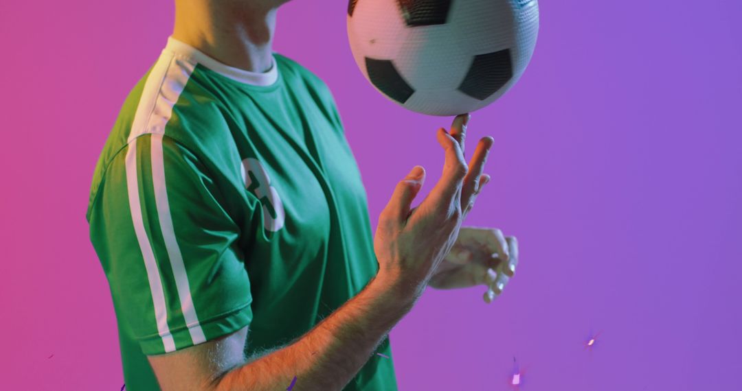 Soccer Player Balancing Ball Against Colorful Background