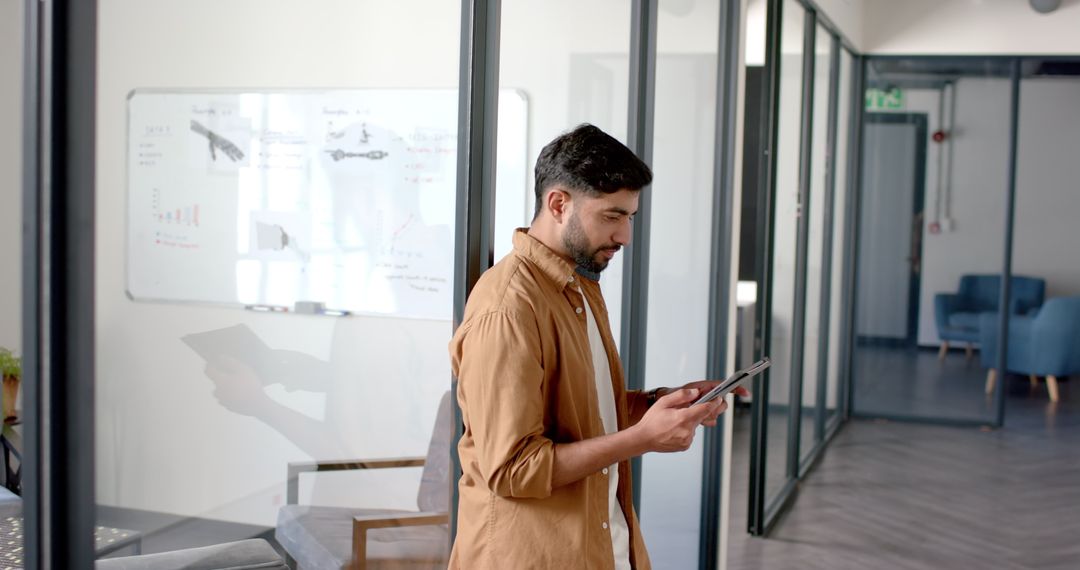 Professional Man Using Tablet in Modern Office Hallway