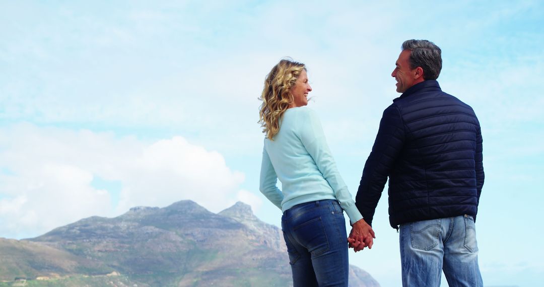 Happy Couple Holding Hands on Mountain View Background - Free Images, Stock Photos and Pictures on Pikwizard.com