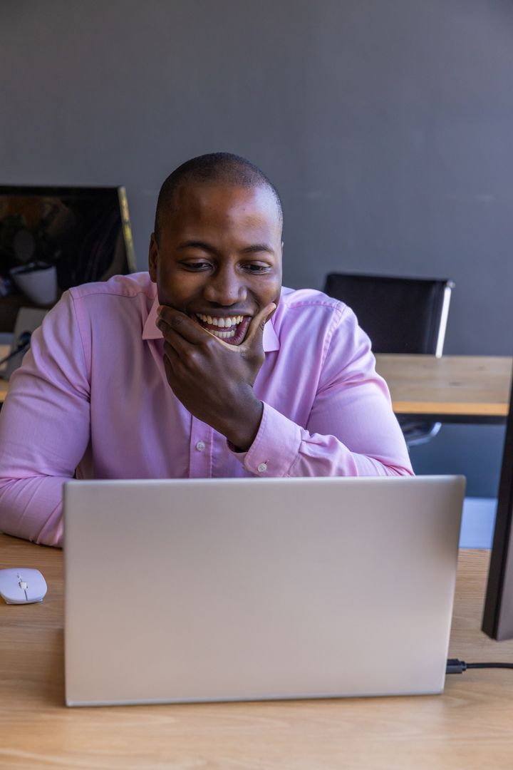 Smiling Professional Man Using Laptop in Modern Office