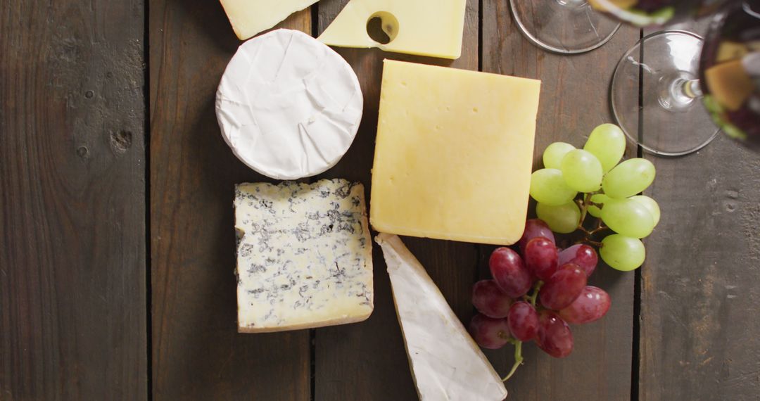 Assorted Cheeses with Grapes on Wooden Table, High Angle View - Free Images, Stock Photos and Pictures on Pikwizard.com