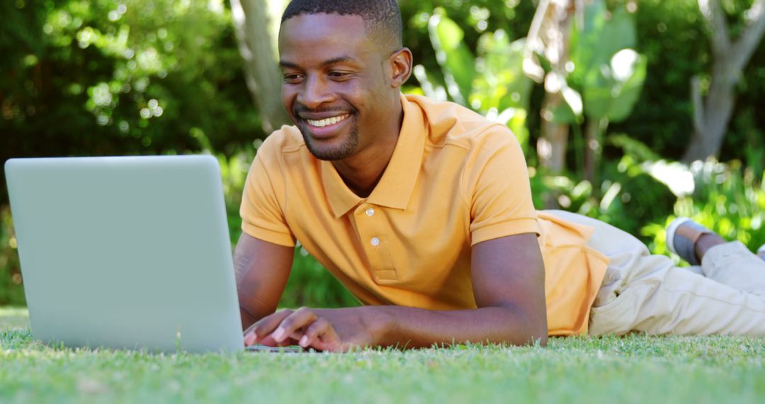 Happy Young Man Using Laptop on Grass in Park - Free Images, Stock Photos and Pictures on Pikwizard.com