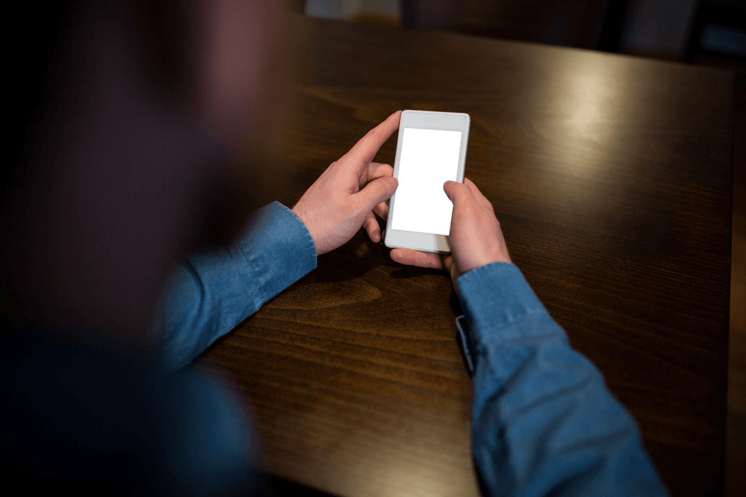 Transparent Smartphone Screen Being Held at Wooden Cafe Table