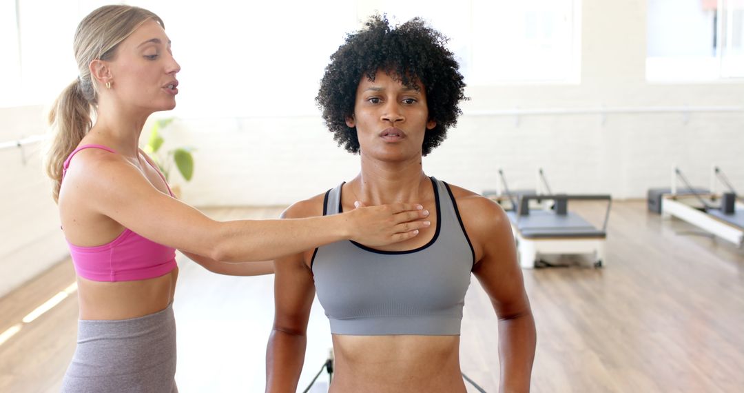 Yoga Instructor Guiding Student in Bright Studio