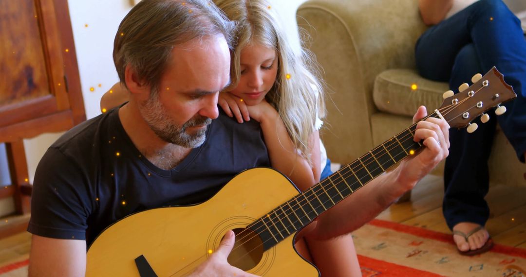 Father playing acoustic guitar with daughter for family bonding