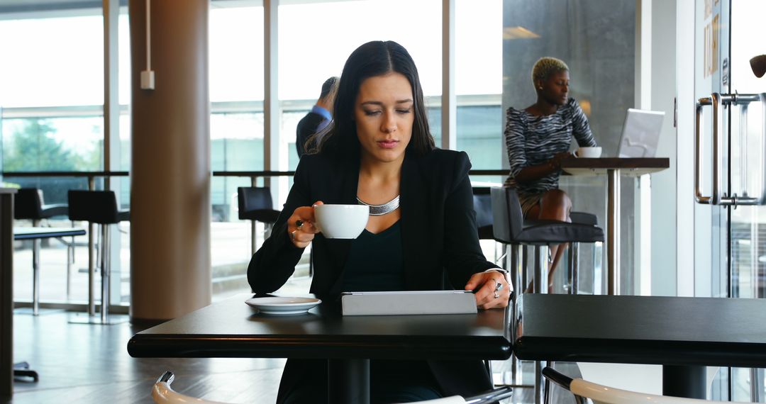 Businesswoman in Cafeteria Using Digital Tablet Relaxing with Coffee