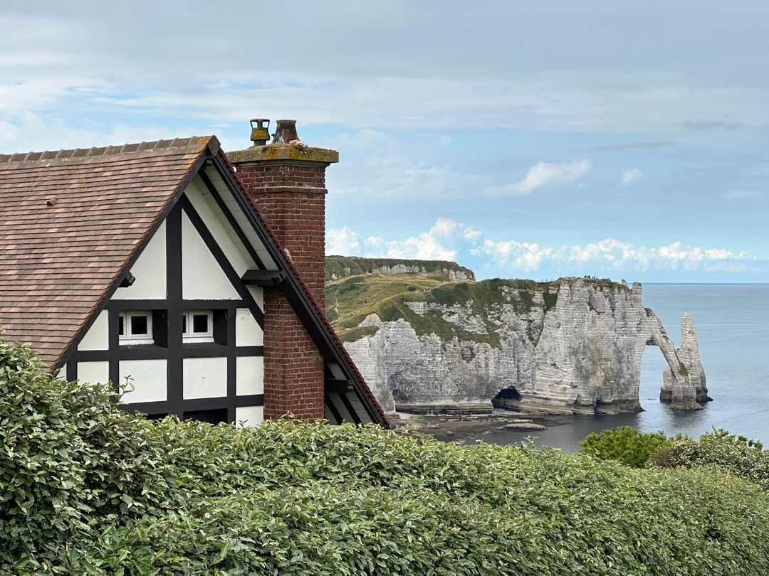 Tudor Cottage Overlooking Chalk Cliffs and Natural Arch on Coastal Cliffside