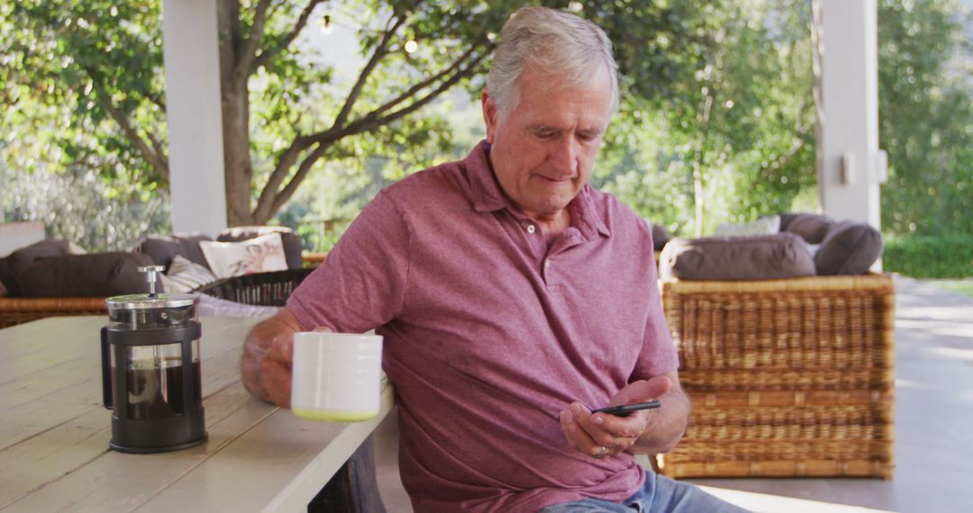 Senior Man Using Smartphone While Enjoying Coffee on Outdoor Patio - Free Images, Stock Photos and Pictures on Pikwizard.com