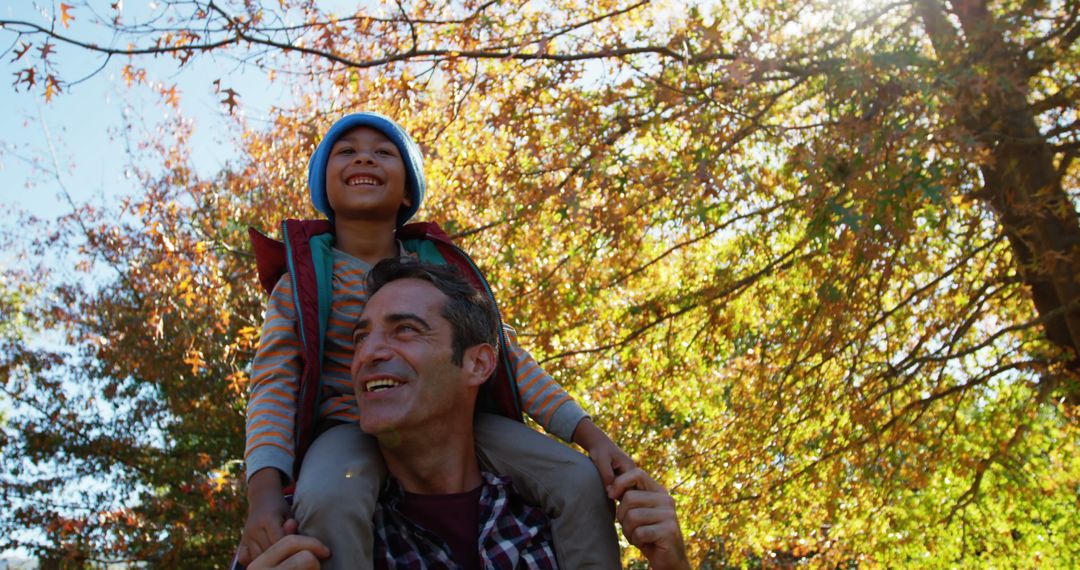 Father Giving Son Piggyback Ride in Autumn Park - Free Images, Stock Photos and Pictures on Pikwizard.com