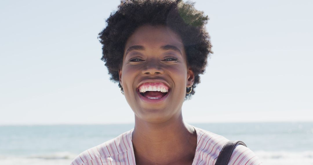 Smiling Woman with Natural Hair at Beach During Summer - Free Images, Stock Photos and Pictures on Pikwizard.com