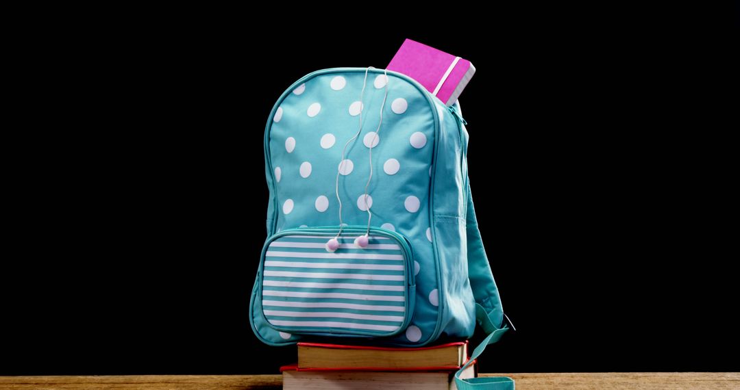 Turquoise Polka Dot Backpack with Book on Wooden Table - Free Images, Stock Photos and Pictures on Pikwizard.com