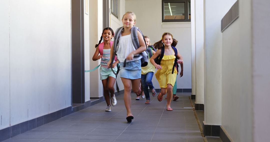 Joyful Schoolchildren Running in School Corridor with Backpacks