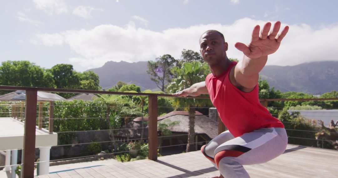 Active Biracial Man Practicing Yoga on Balcony with View