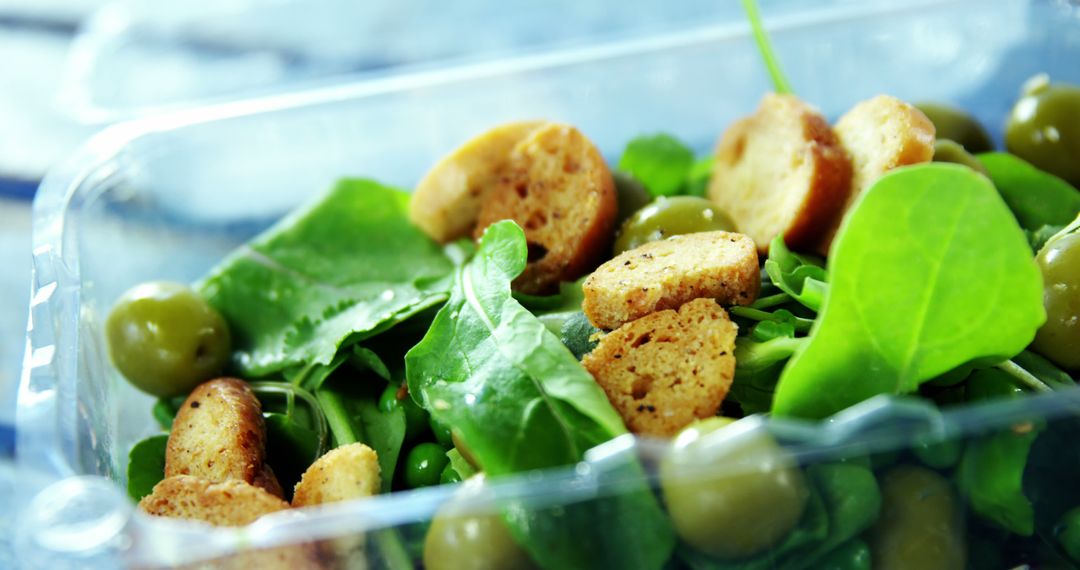 Healthy Spinach Salad with Olives and Croutons in Plastic Container - Free Images, Stock Photos and Pictures on Pikwizard.com