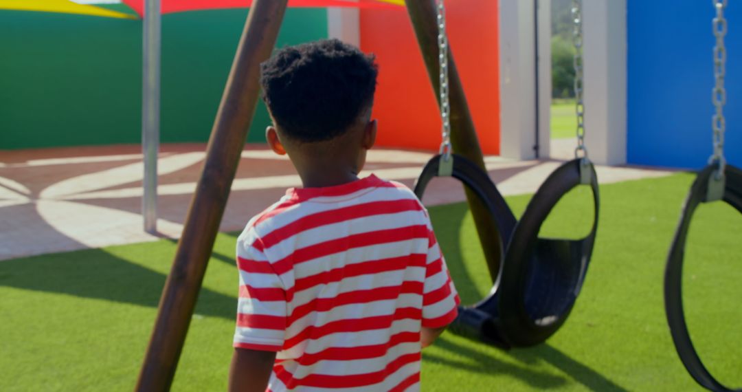 Schoolboy Running Towards Swing in Vibrant Playground