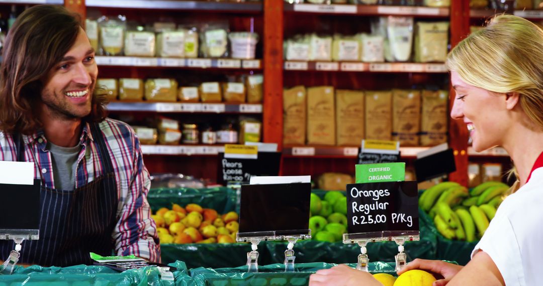 Smiling Grocer Helping Woman with Fresh Produce Purchase in Store - Free Images, Stock Photos and Pictures on Pikwizard.com