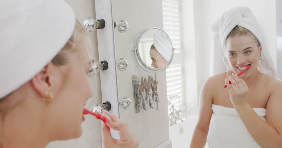 Woman Brushing Teeth in Modern Bathroom Mirror - Free Images, Stock Photos and Pictures on Pikwizard.com