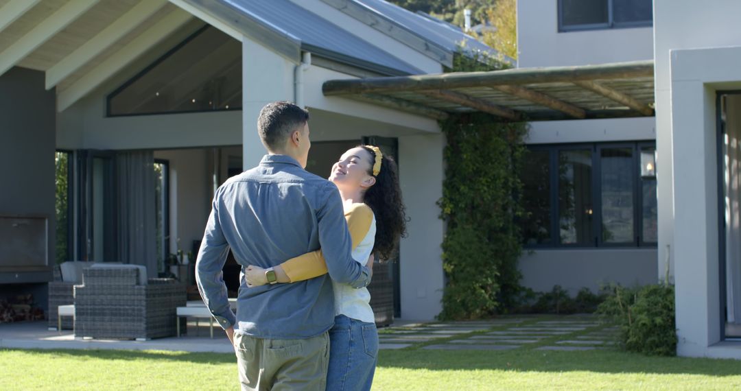 Diverse Couple Hugging in Front of Modern Home