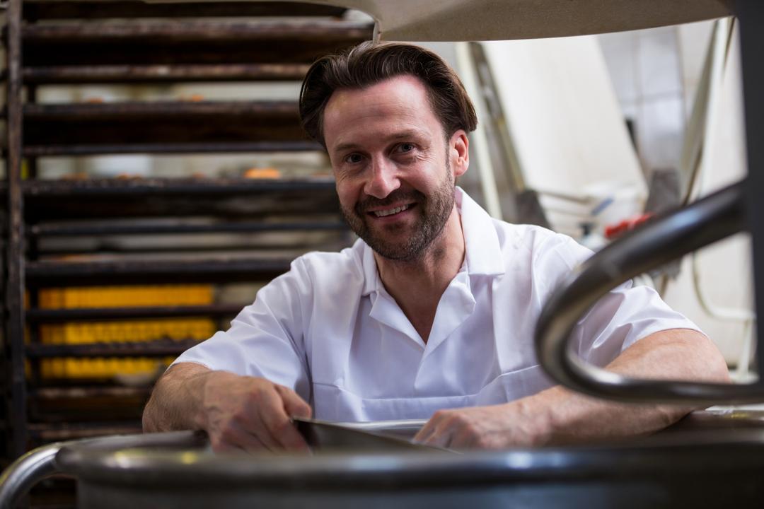 Smiling Baker Standing Near Dough Machine in Bakery - Free Images, Stock Photos and Pictures on Pikwizard.com