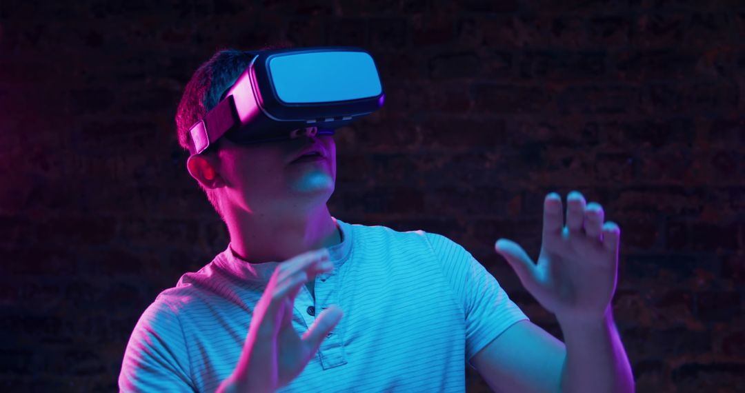 Man Immersed in Virtual Reality with VR Headset in Neon Light - Free Images, Stock Photos and Pictures on Pikwizard.com
