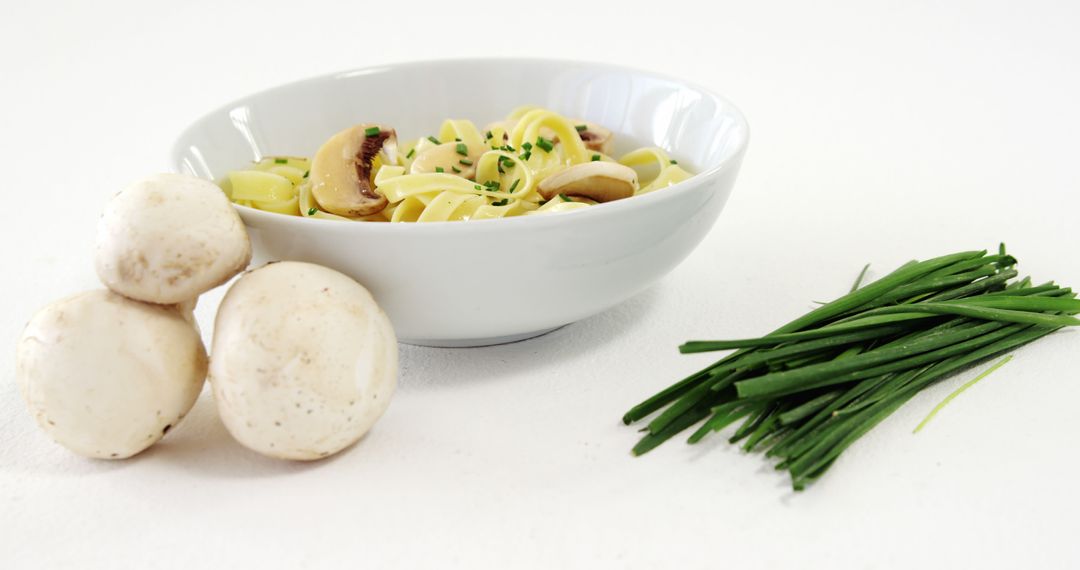 Linguine Pasta with Mushrooms and Chives on White Background - Free Images, Stock Photos and Pictures on Pikwizard.com