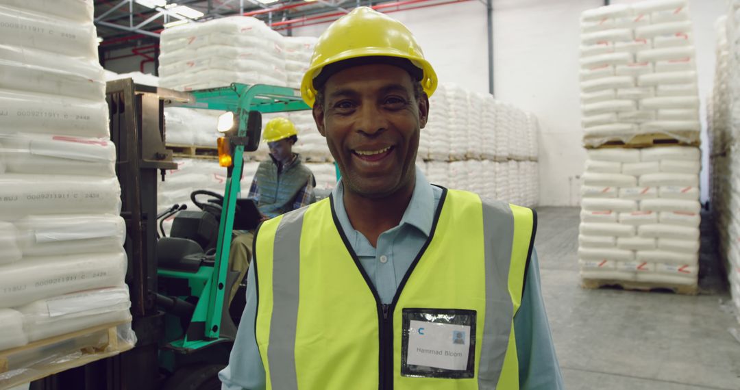 Worker Wearing Safety Gear Smiling in Warehouse Storage - Free Images, Stock Photos and Pictures on Pikwizard.com