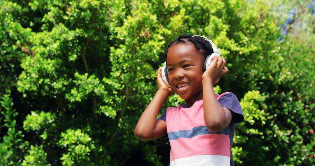 Smiling African American Boy Listening to Music with Headphones Outdoors - Free Images, Stock Photos and Pictures on Pikwizard.com