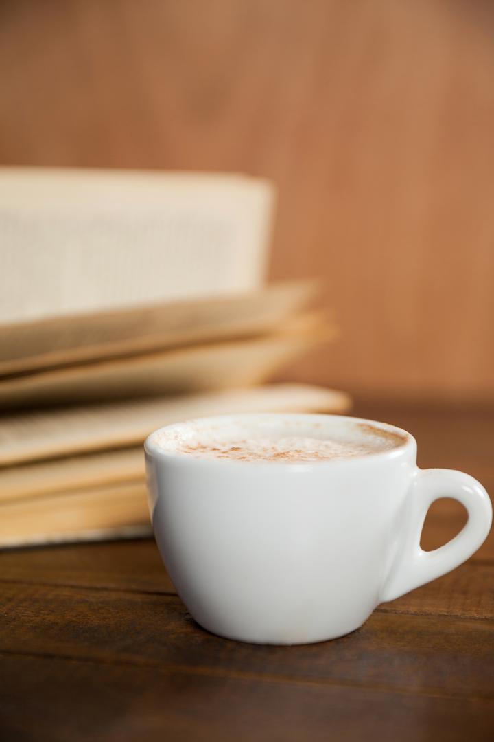 Close-Up of Coffee Cup and Book on Wooden Table - Free Images, Stock Photos and Pictures on Pikwizard.com