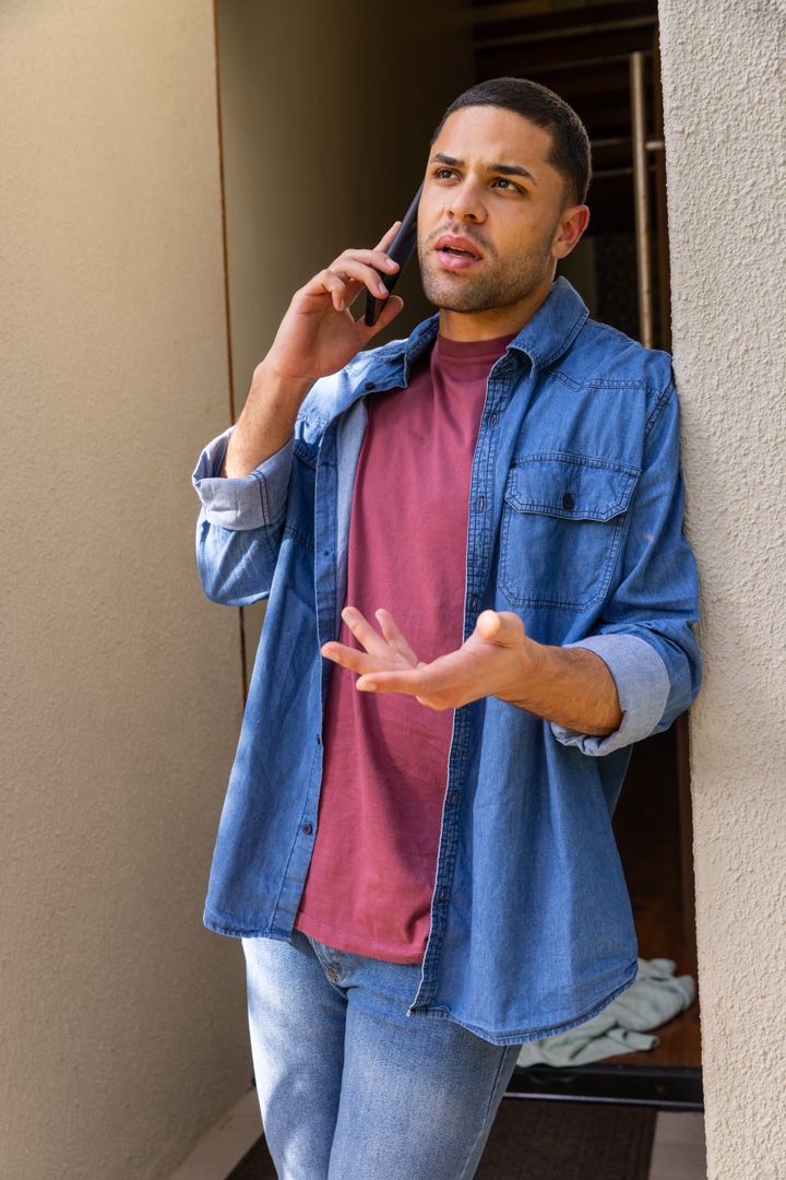 Young Man Communicating Assertively on Smartphone in Urban Home