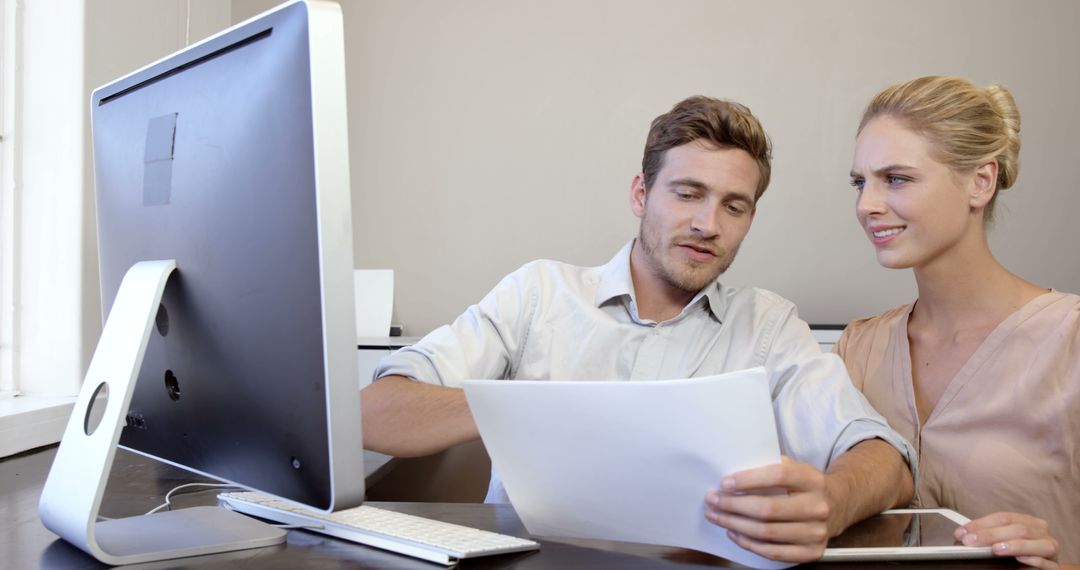 Colleagues Analyzing Documents and Working on Computer