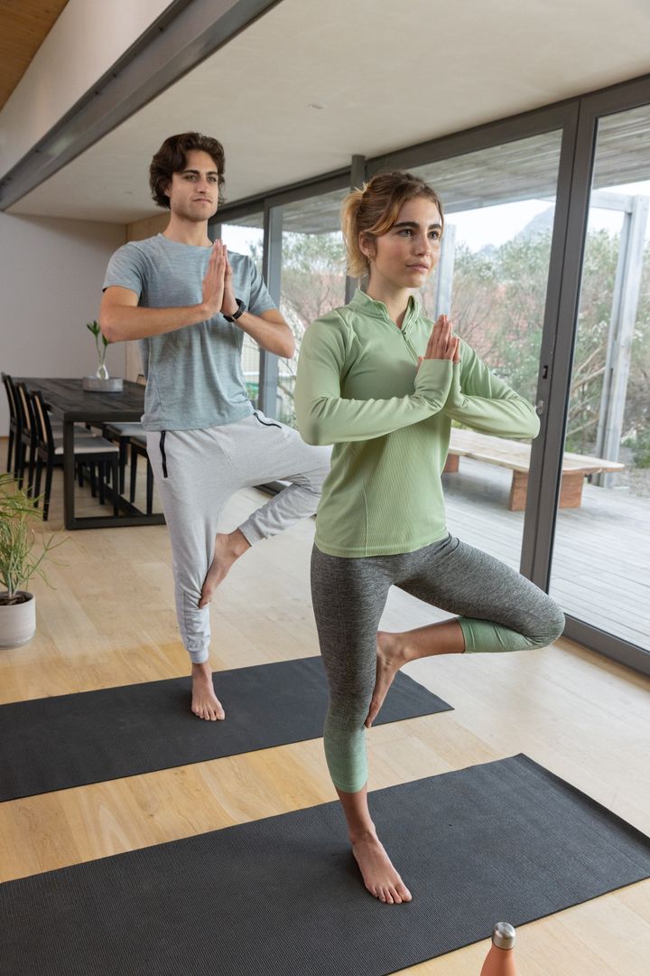 Couple Practicing Yoga in Modern Interior for Harmony and Balance