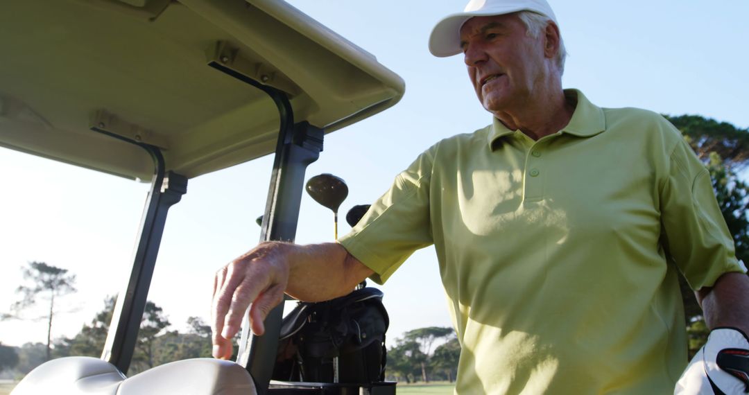 Golfer driving in his golf buggy at golf course - Free Images, Stock Photos and Pictures on Pikwizard.com